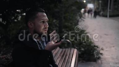 休闲快乐的人坐在公园的长凳上，游客使用语音识别人工语音辅助音频
